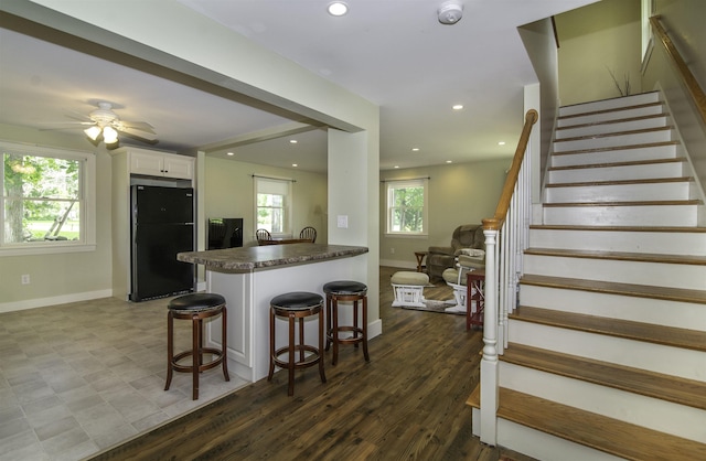 153 N Rd, Brentwood, NH 03833 - kitchen with freestanding refrigerator, dark countertops, white cabinetry, a peninsula, and a breakfast bar area