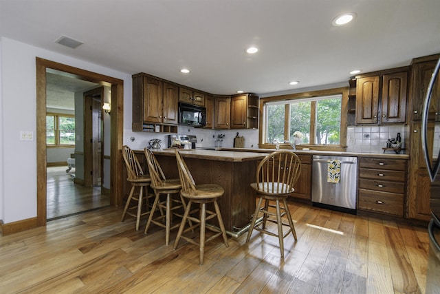 153 N Rd, Brentwood, NH 03833 - kitchen with appliances with stainless steel finishes, light wood-style floors, recessed lighting, a breakfast bar area, and open shelves