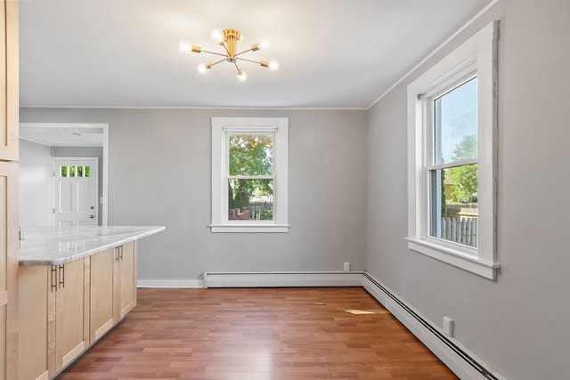 24B Grand Ave, Nashua, NH 03060 - unfurnished dining area with baseboard heating, light wood-type flooring, and a chandelier