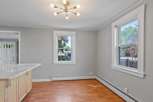 24B Grand Ave, Nashua, NH 03060 - unfurnished dining area featuring a baseboard heating unit, plenty of natural light, a chandelier, light wood-type flooring, and ornamental molding