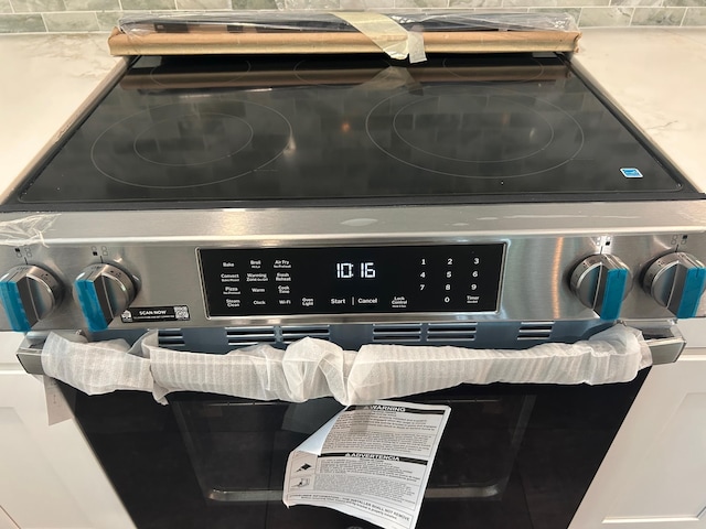 32 Muddy Pond Rd, Kensington, NH 03833 - detailed view of stainless steel electric stove, backsplash, and oven