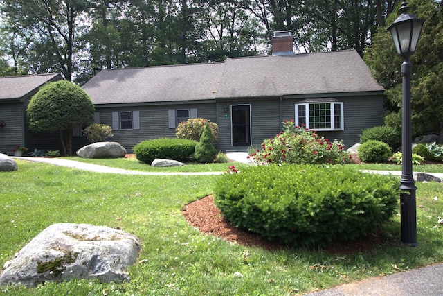 7 Minuteman Ln Unit 7, Exeter, NH 03833 - view of front of property featuring a chimney, a front yard, and roof with shingles