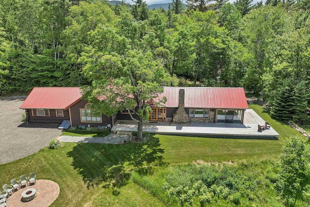 83 Towle Rd, Jackson, NH 03846 - view of front of property with a metal roof, a front yard, a view of trees, a fire pit, and french doors