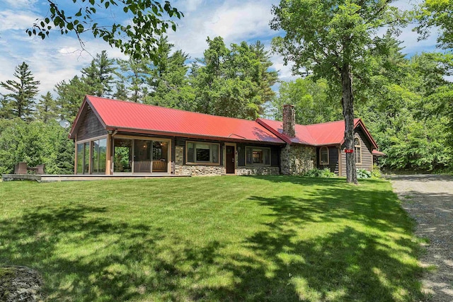83 Towle Rd, Jackson, NH 03846 - view of front of house with stone siding, a chimney, a front lawn, and a metal roof