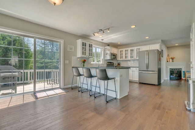 15 Winslow Dr, Somersworth, NH 03878 - kitchen with stainless steel appliances, a peninsula, white cabinetry, glass insert cabinets, and dark wood-style flooring
