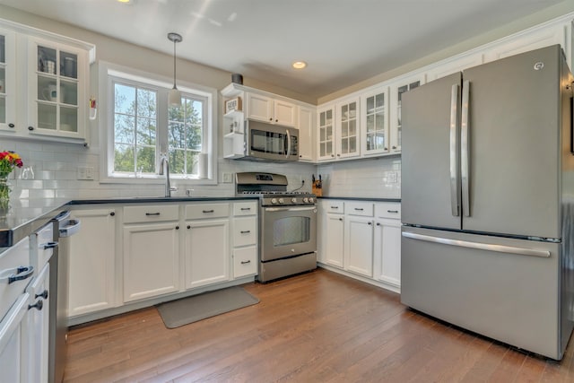 15 Winslow Dr, Somersworth, NH 03878 - kitchen featuring stainless steel appliances, dark countertops, wood finished floors, backsplash, and white cabinets