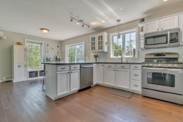 15 Winslow Dr, Somersworth, NH 03878 - kitchen with stainless steel appliances, a baseboard heating unit, dark countertops, and a peninsula