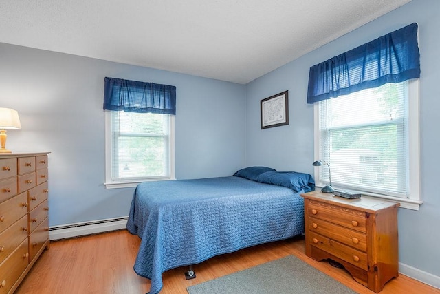 6 Lacy Ln, Nashua, NH 03062 - bedroom with a baseboard heating unit, multiple windows, and light wood-type flooring