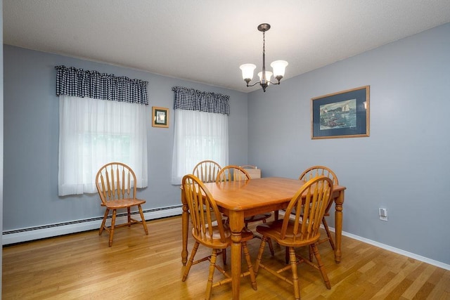 6 Lacy Ln, Nashua, NH 03062 - dining room featuring light wood-style flooring, a chandelier, and a baseboard radiator