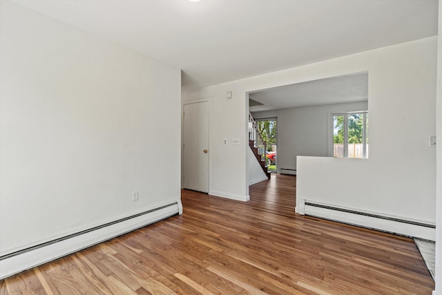 9 Bryant Rd, Nashua, NH 03062 - spare room featuring baseboard heating, a baseboard heating unit, light wood-style floors, and stairs