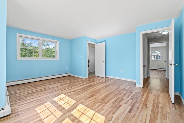 9 Bryant Rd, Nashua, NH 03062 - unfurnished bedroom with baseboard heating, light wood-style floors, and a baseboard heating unit