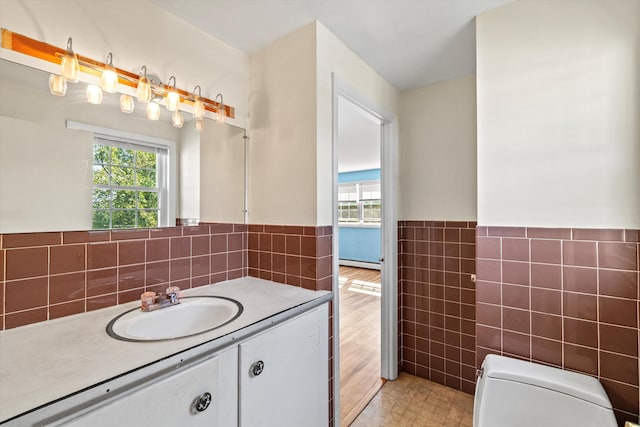 9 Bryant Rd, Nashua, NH 03062 - bathroom featuring tile walls, vanity, wainscoting, and a baseboard radiator