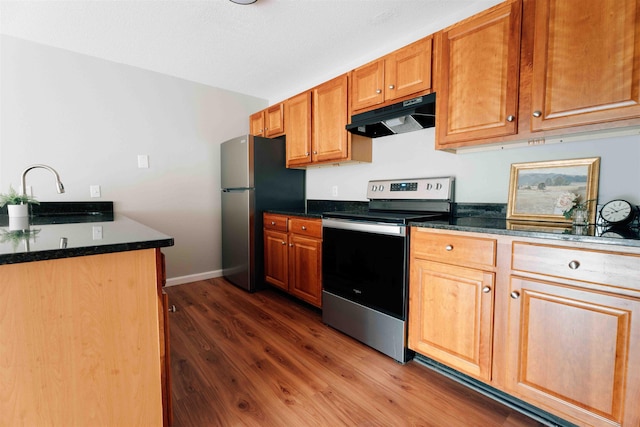 120 Fisherville Rd Unit 29, Concord, NH 03303 - kitchen featuring under cabinet range hood, appliances with stainless steel finishes, dark wood finished floors, and brown cabinets