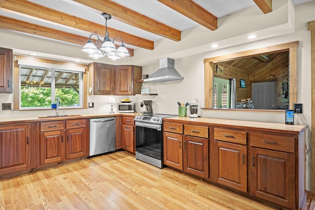 43 Knights Pond Rd, South Berwick, ME 03908 - kitchen featuring appliances with stainless steel finishes, wall chimney range hood, brown cabinetry, light wood finished floors, and a chandelier