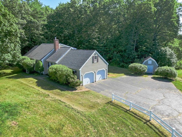 144 Packers Falls Rd, Durham, NH 03824 - view of property exterior with a storage unit, driveway, a chimney, and a lawn