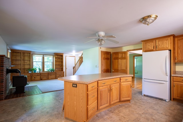 144 Packers Falls Rd, Durham, NH 03824 - kitchen featuring freestanding refrigerator, a wood stove, a kitchen island, ceiling fan, and open floor plan