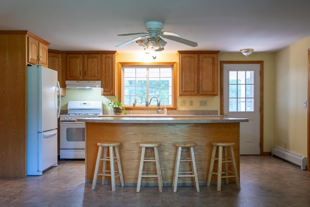 144 Packers Falls Rd, Durham, NH 03824 - kitchen featuring under cabinet range hood, white appliances, a baseboard radiator, and a kitchen breakfast bar