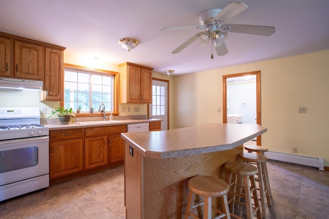 144 Packers Falls Rd, Durham, NH 03824 - kitchen with gas range gas stove, under cabinet range hood, baseboard heating, a breakfast bar area, and a kitchen island