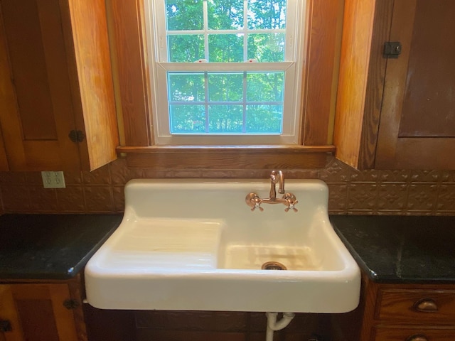 34 Dewey St, Springfield, VT 05156 - kitchen view of dark countertops, decorative backsplash, and brown cabinetry