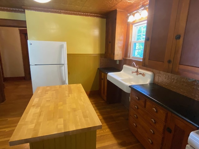 34 Dewey St, Springfield, VT 05156 - kitchen featuring freestanding refrigerator, butcher block countertops, light wood-type flooring, brown cabinetry, and a wainscoted wall