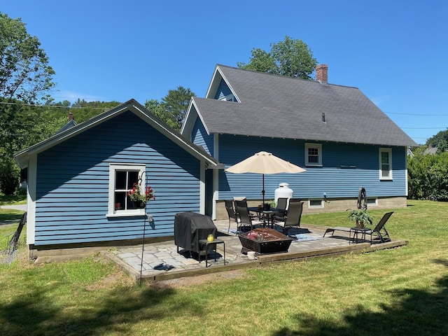 34 Dewey St, Springfield, VT 05156 - rear view of house featuring a lawn, a patio, a chimney, a fire pit, and a shingled roof