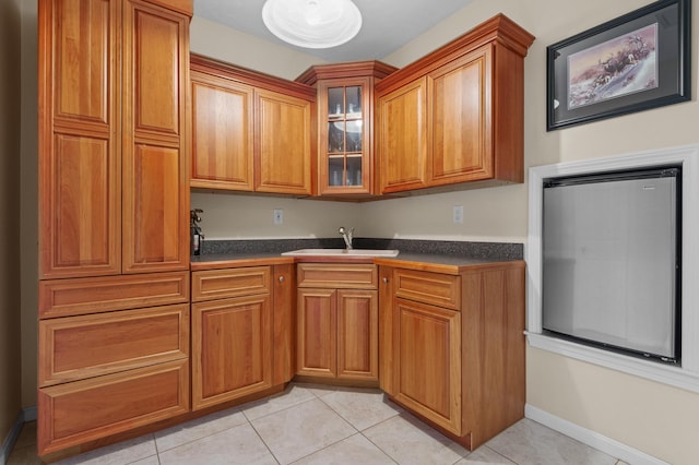 53 Ammonoosuc Dr, Bartlett, NH 03812 - kitchen featuring dark countertops, brown cabinetry, glass insert cabinets, and light tile patterned floors