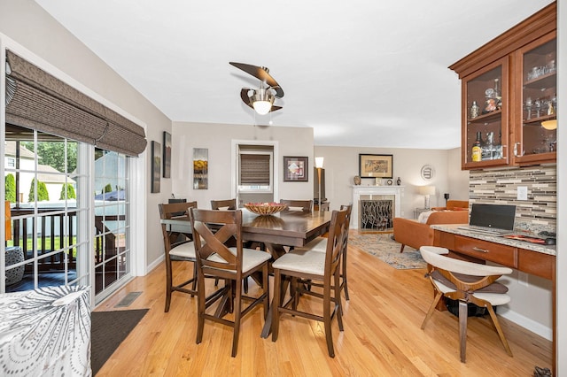 4 Chestnut St, Hudson, NH 03051 - dining room with light wood-type flooring, a fireplace, and an office area