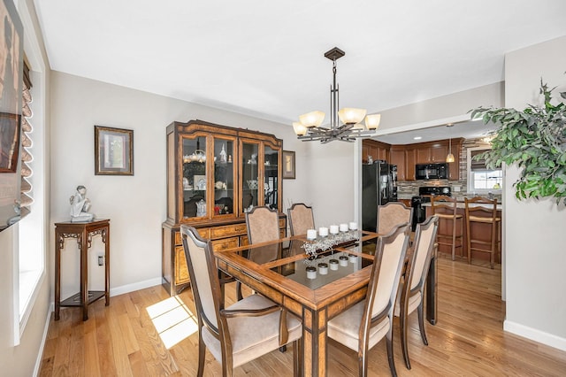 4 Chestnut St, Hudson, NH 03051 - dining area featuring a chandelier and light wood-style flooring