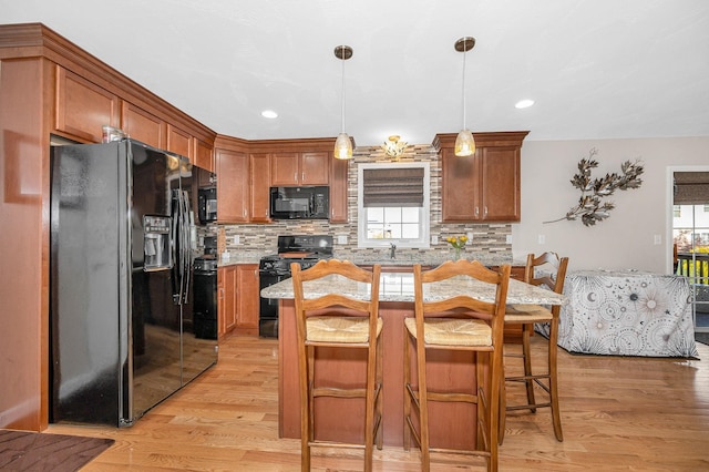 4 Chestnut St, Hudson, NH 03051 - kitchen with black appliances, light wood-type flooring, brown cabinetry, and recessed lighting