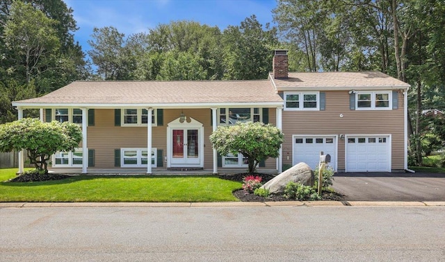 55 Robinhood Rd, Nashua, NH 03062 - view of front of house with a chimney, driveway, an attached garage, and a front yard