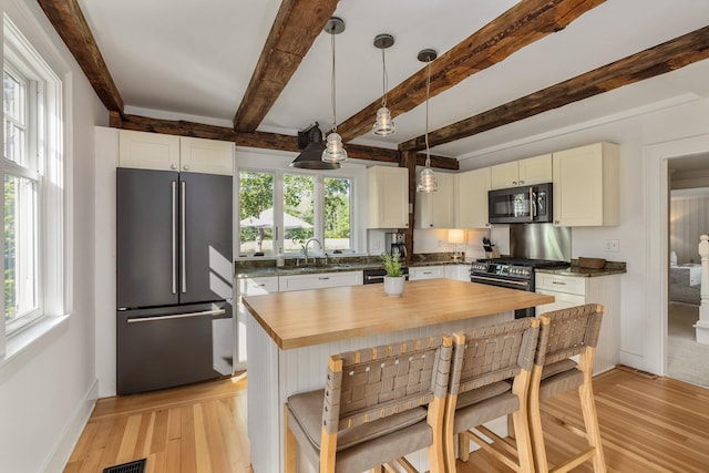 45 Atlantic Ave, North Hampton, NH 03862 - kitchen with high end appliances, butcher block countertops, beamed ceiling, light wood-type flooring, and hanging light fixtures