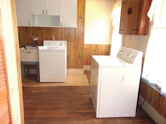 70 Wild Ammonoosuc Rd, Haverhill, NH 03785 - washroom featuring cabinet space, separate washer and dryer, wood finished floors, and wooden walls