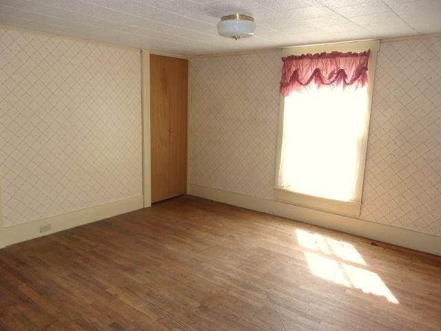 70 Wild Ammonoosuc Rd, Haverhill, NH 03785 - empty room with wood finished floors and wallpapered walls
