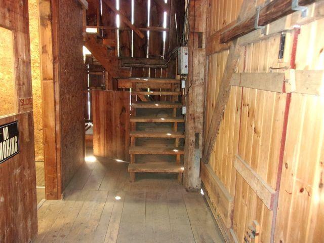 70 Wild Ammonoosuc Rd, Haverhill, NH 03785 - staircase featuring wood walls and hardwood / wood-style floors