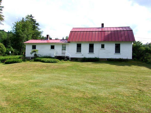 70 Wild Ammonoosuc Rd, Haverhill, NH 03785 - back of property featuring a chimney, a standing seam roof, and a yard
