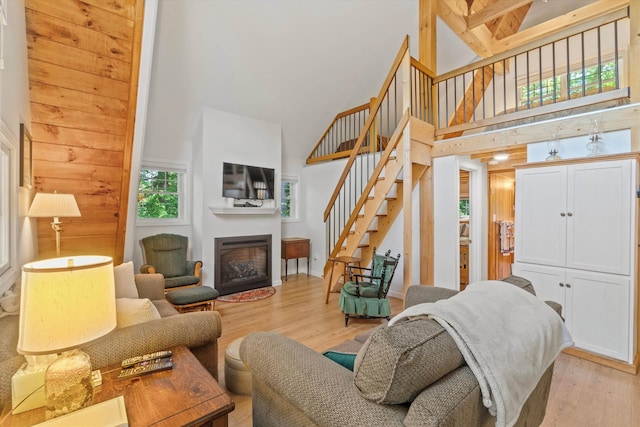 73 Lost Ln, Deering, NH 03244 - living room with a high ceiling, a fireplace, stairway, and light wood-style flooring