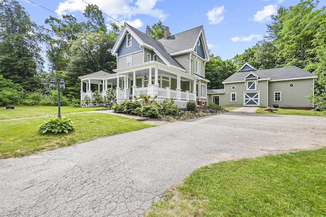 11 Palmer Ave, Plaistow, NH 03865 - view of front of property featuring covered porch, a front lawn, an outdoor structure, a chimney, and roof with shingles