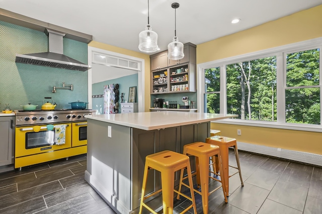 11 Palmer Ave, Plaistow, NH 03865 - kitchen with range with two ovens, wall chimney exhaust hood, light countertops, gray cabinets, and decorative backsplash