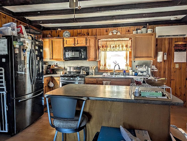 5559 W Creek Rd, Brandon, VT 05733 - kitchen with black appliances, wood finished floors, beamed ceiling, a wall mounted air conditioner, and brown cabinetry