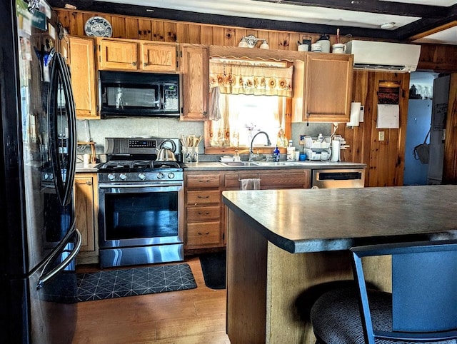 5559 W Creek Rd, Brandon, VT 05733 - kitchen featuring black appliances, dark wood-style flooring, a wall mounted air conditioner, a breakfast bar area, and brown cabinets