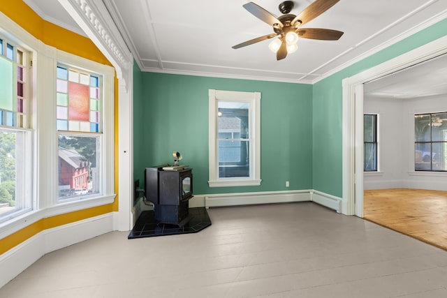 10 Prospect St, Somersworth, NH 03878 - unfurnished room featuring baseboard heating, plenty of natural light, a wood stove, ceiling fan, and crown molding