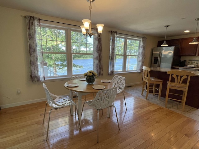 207 Long Pond Rd, Danville, NH 03819 - dining space featuring light wood-style flooring, a chandelier, and a water view