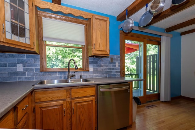 4B Pine Isle Dr Unit B, Derry, NH 03038 - kitchen with stainless steel dishwasher, tasteful backsplash, light wood-style floors, beamed ceiling, and brown cabinetry
