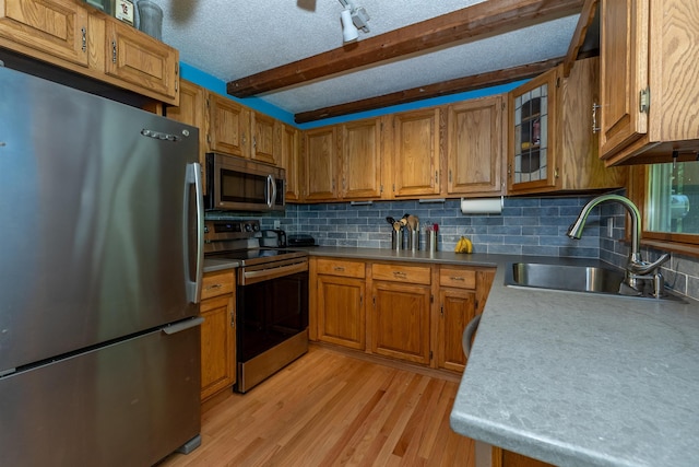 4B Pine Isle Dr Unit B, Derry, NH 03038 - kitchen with appliances with stainless steel finishes, brown cabinetry, decorative backsplash, beamed ceiling, and glass insert cabinets