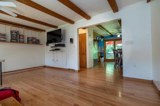 4B Pine Isle Dr Unit B, Derry, NH 03038 - unfurnished living room featuring a ceiling fan, beamed ceiling, light wood-style flooring, and a textured ceiling