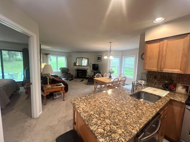 8B Deer Crk, Dover, VT 05356 - kitchen featuring light colored carpet, dishwashing machine, a peninsula, a fireplace, and open floor plan