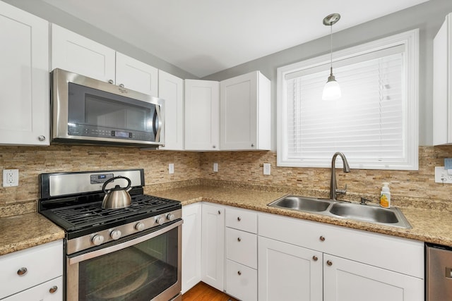 16 Damsite Rd, Barnstead, NH 03225 - kitchen featuring appliances with stainless steel finishes, white cabinets, decorative backsplash, hanging light fixtures, and light countertops
