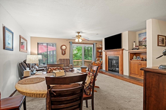 79 Dunvegan Woods Dr Unit 79, Hampton, NH 03842 - carpeted dining area featuring a glass covered fireplace, a ceiling fan, and a textured ceiling