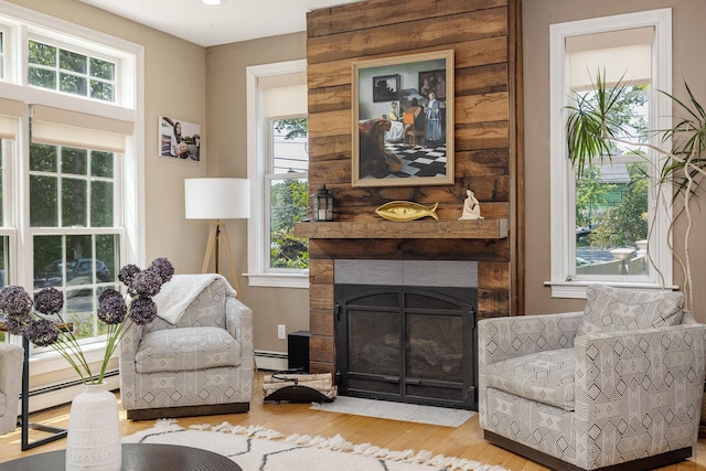 201 Walker Bungalow Rd, Portsmouth, NH 03801 - sitting room with wood finished floors, a fireplace with flush hearth, and baseboard heating