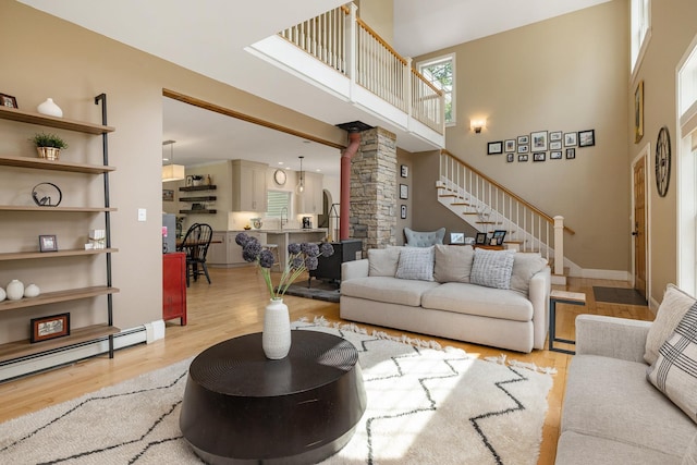 201 Walker Bungalow Rd, Portsmouth, NH 03801 - living area featuring decorative columns, wood finished floors, stairway, and a high ceiling